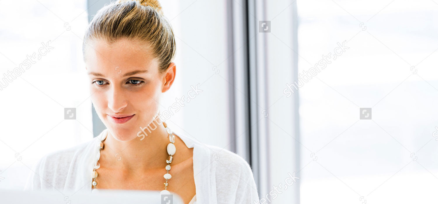 stock-photo-attractive-young-woman-sitting-at-desk-and-working-on-her-computer-521792824